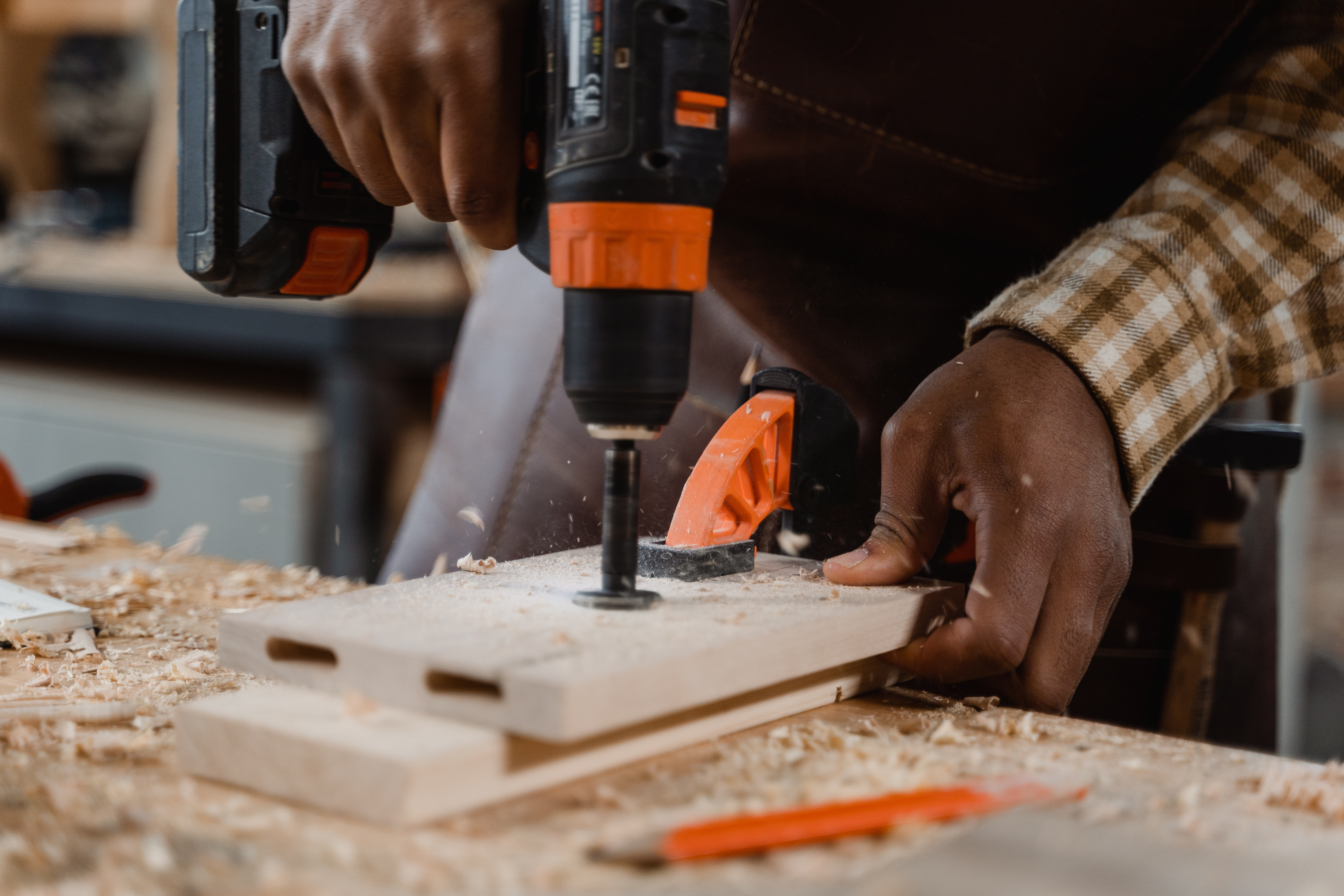 A person uses a drill on a wood project.