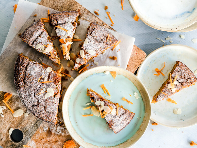 A cake has been sliced on a wooden board and put onto plates