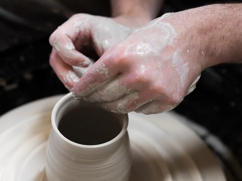 A close up of David Partington of Partington's Pots making a pot on the pottery wheel