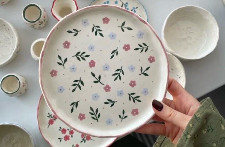 A ceramic paint with painted flowers and leaves