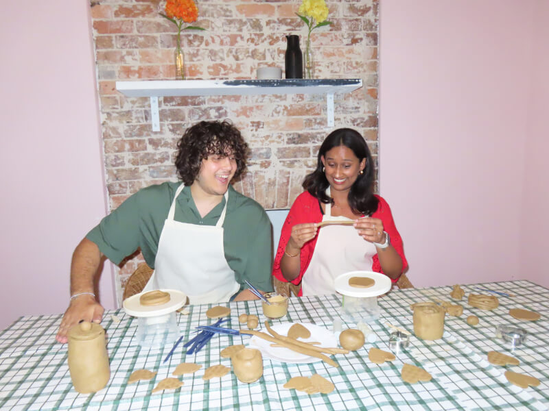 Smiling man and woman working with clay in a pottery class