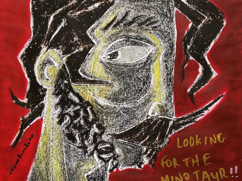 A handmade print of a face in red, yellow and black ink