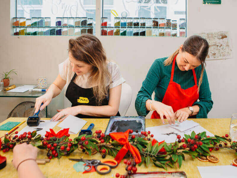 Two women doing festive crafts in a printing class. 