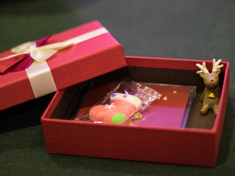 A christmas present containing a sweet and reindeer decoration