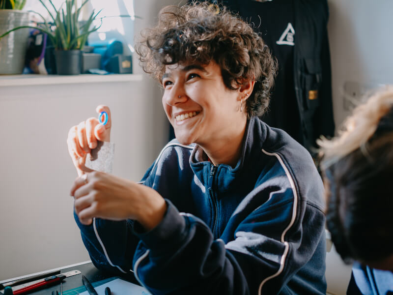 Woman smiling in a jewellery making class.