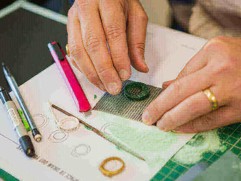 Hands shaping a wax ring in a jewellery making class