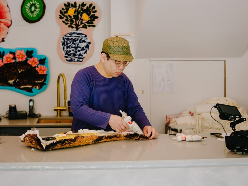 Man tufting a rug 