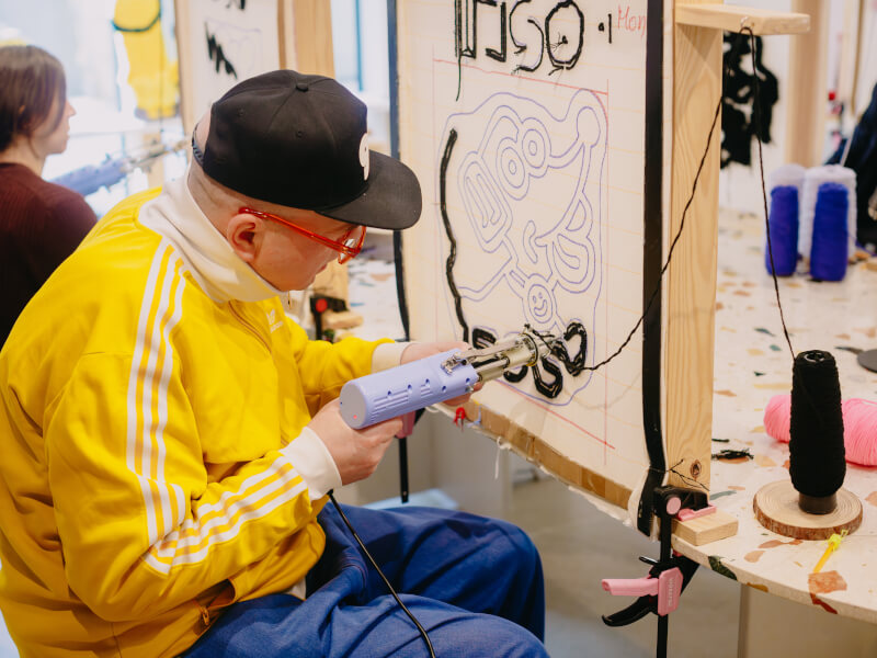 Man using a tufting gun in a rug tufting class