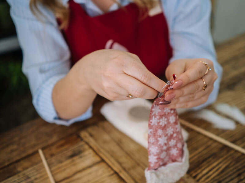 A close up of someone's hands holding fabric and hand sewing it together