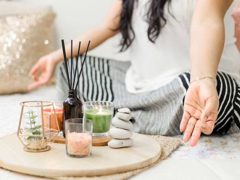 A tray of candles, salts, a small plant and some pebbles