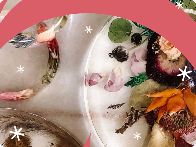 Several pieces of different shaped resin art with flowers, leaves and buds
