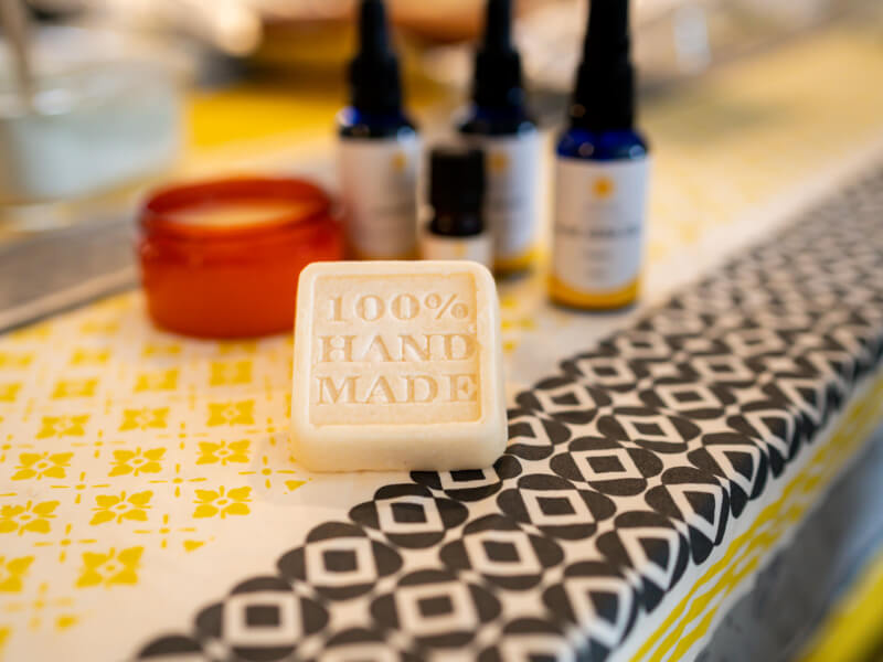 A finished bar of DIY soap with the words '100% hand made' engraved into it
