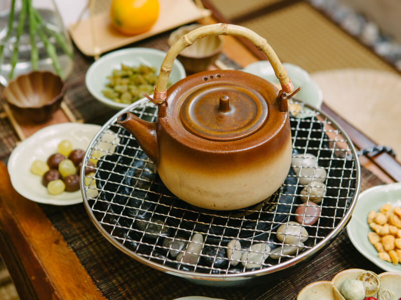 A teapot and other tea ceremony equipment sits on a table