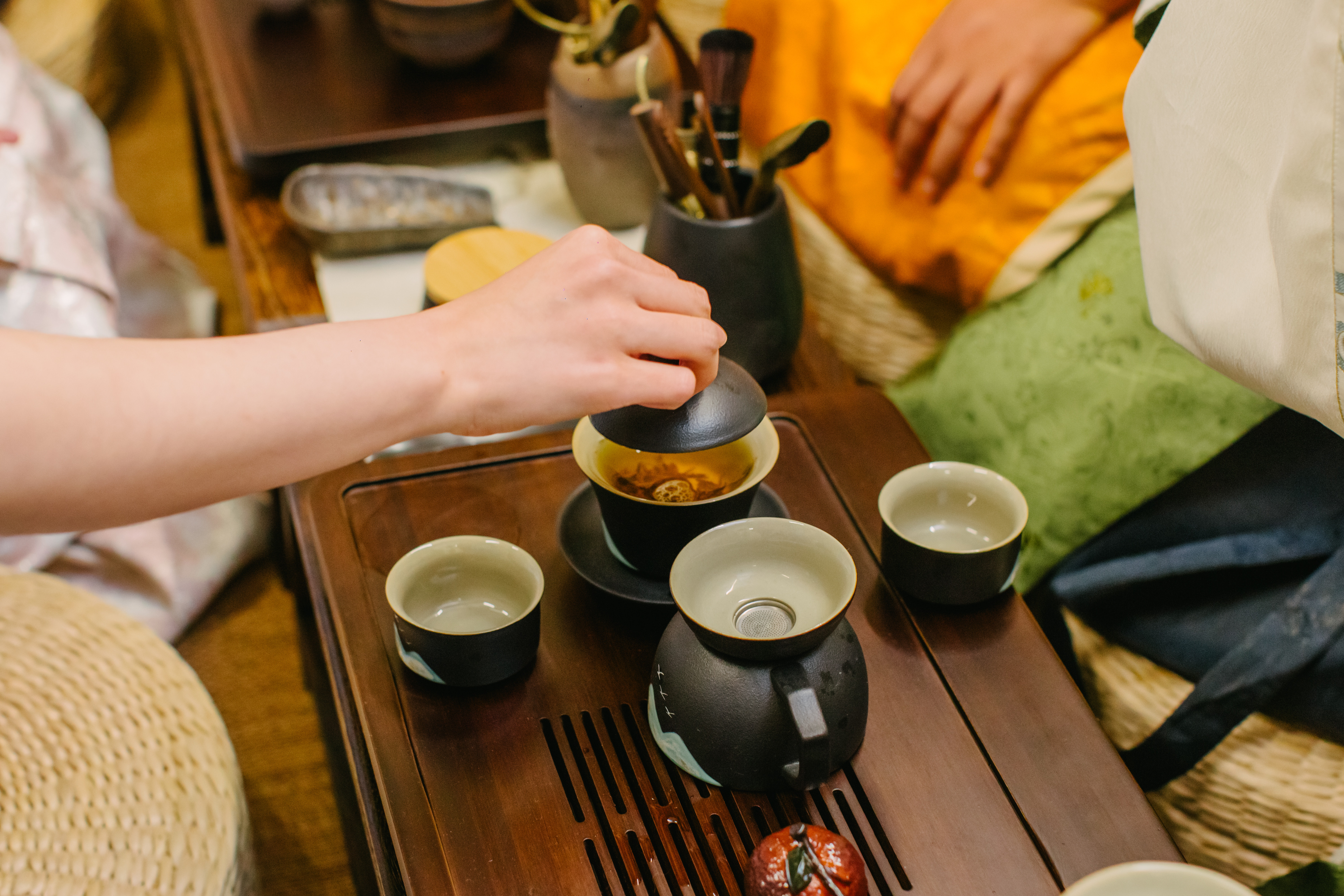 A close up of a person preparing the tea at a tea tasting class