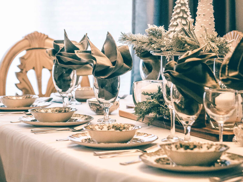 A festively themed laid table decorated with christmas trees