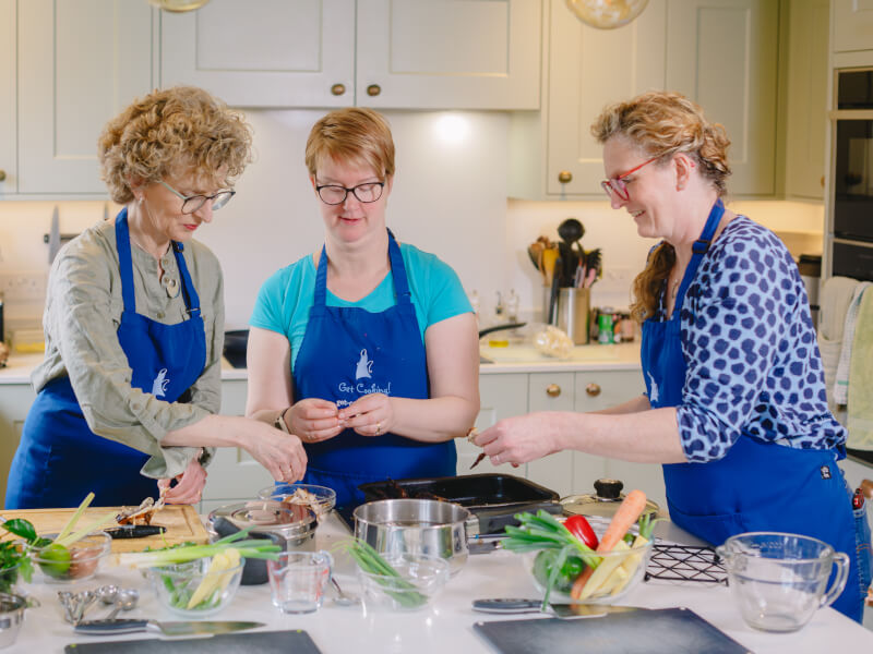 Three woman are preparing ingredients to make Thai food