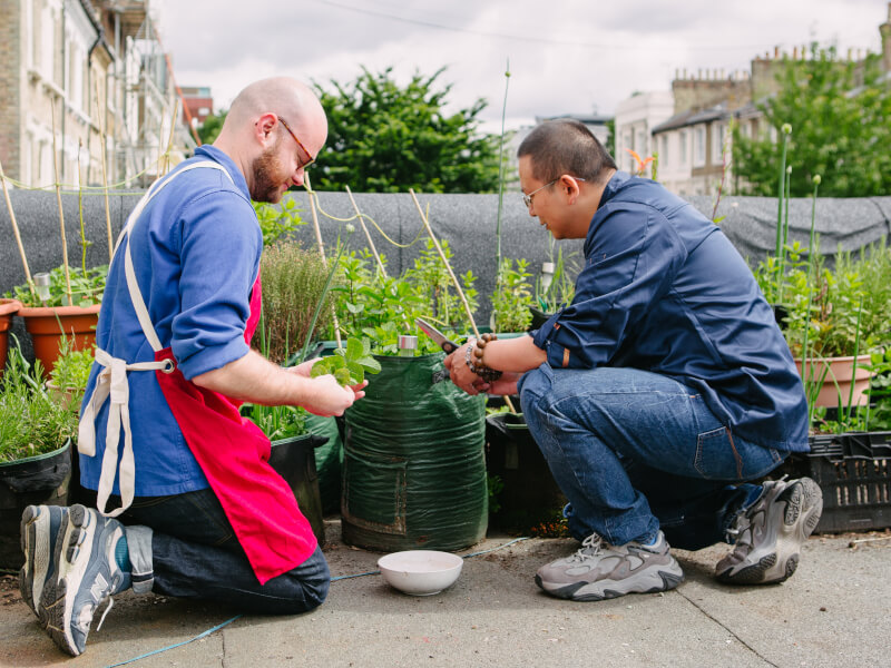 Two men working with plants in a gardening class
