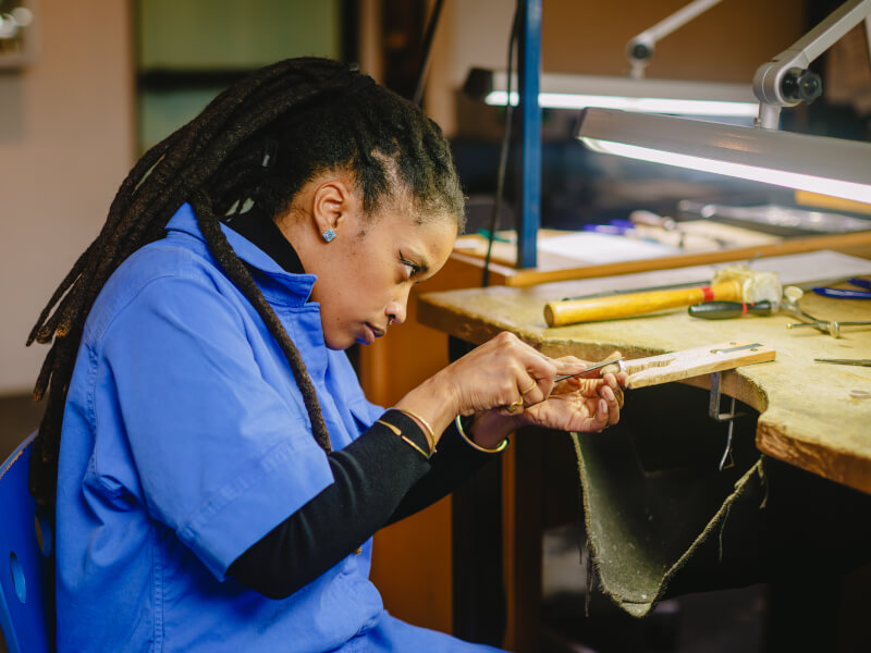 A woman making a ring in a jewellery class