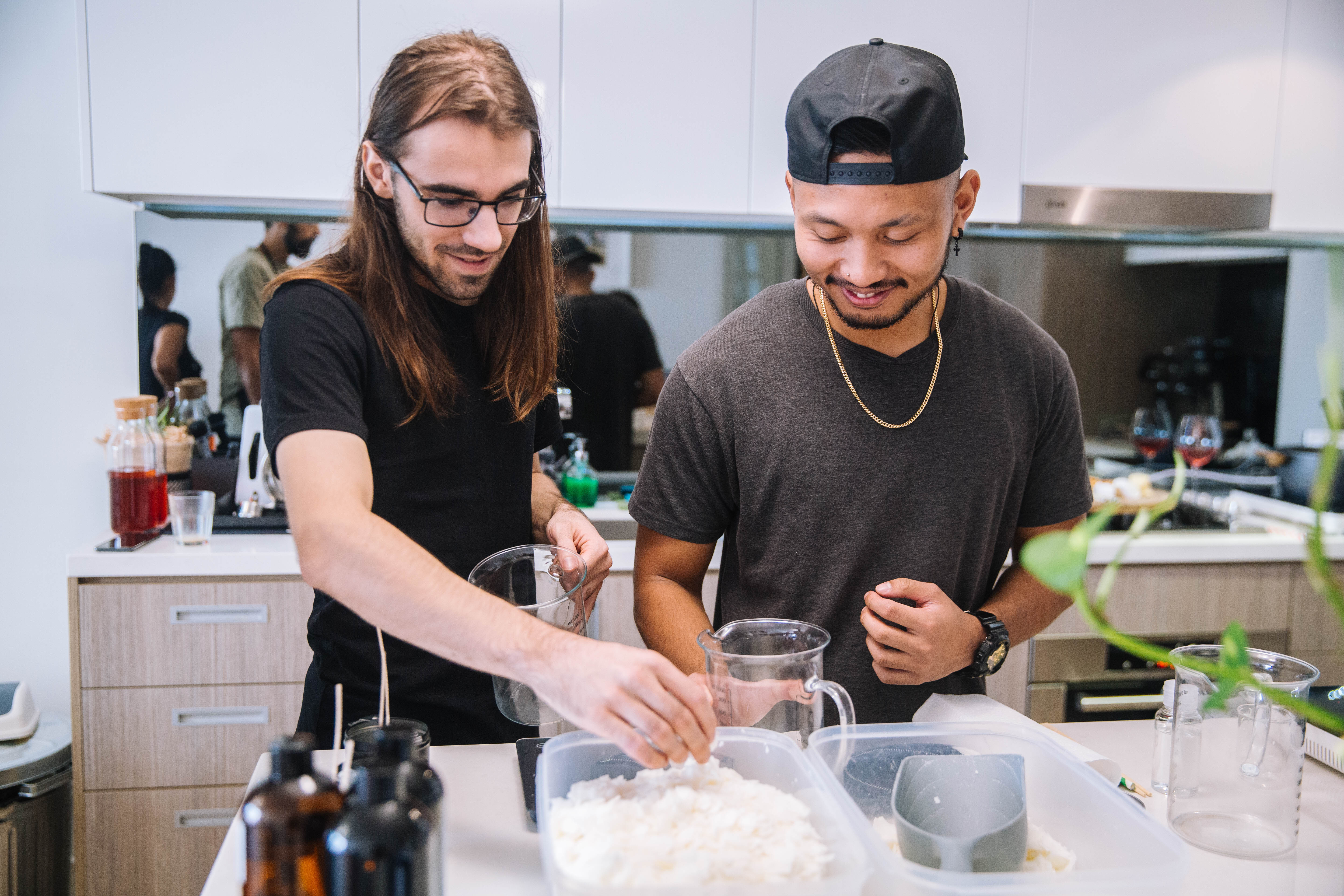 Two men making hand poured soy candles 