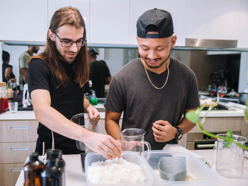 Two men are making candles at a candle making class