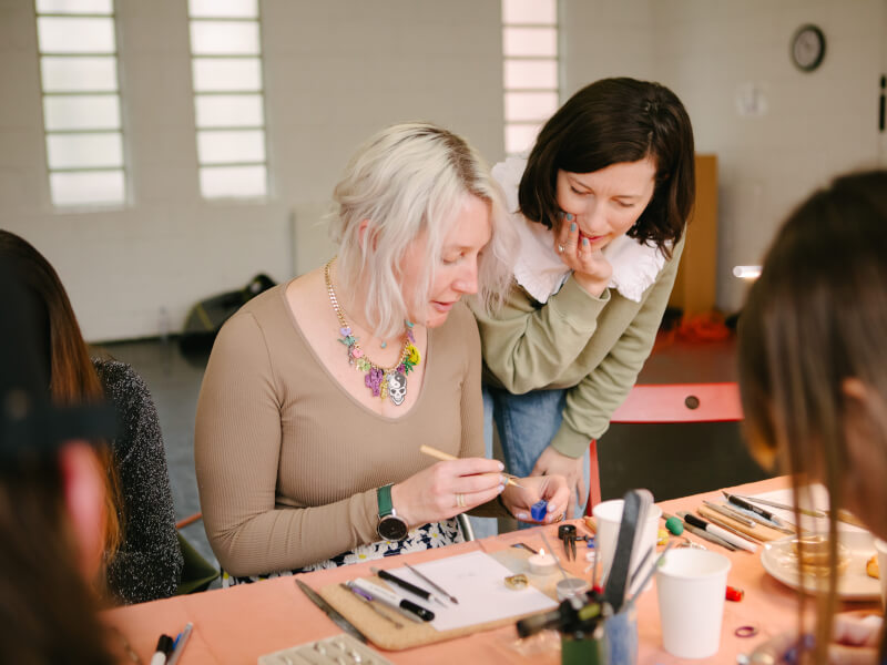 Two women at a jewellery making class, talking
