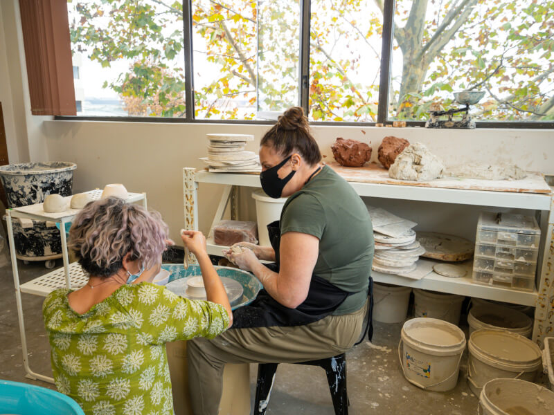 Two people working in a pottery studio