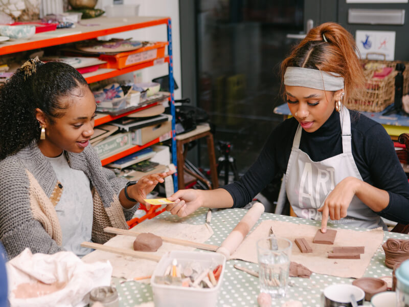 Two women working with clay in a pottery class