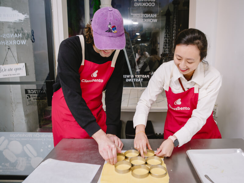 Man and woman using dough in a baking class