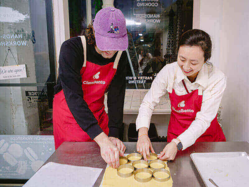 Smiling couple working with dough in a baking class