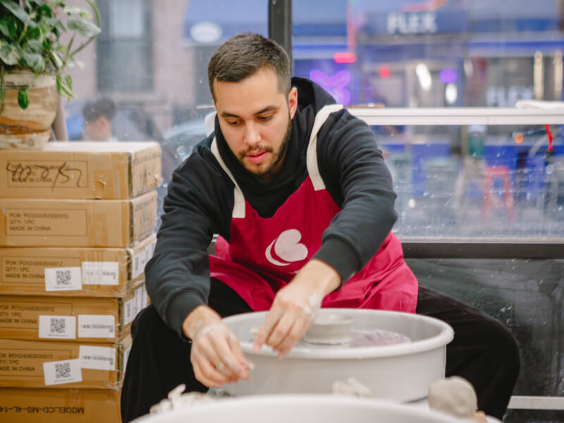 Man using a pottery wheel in a ceramics class
