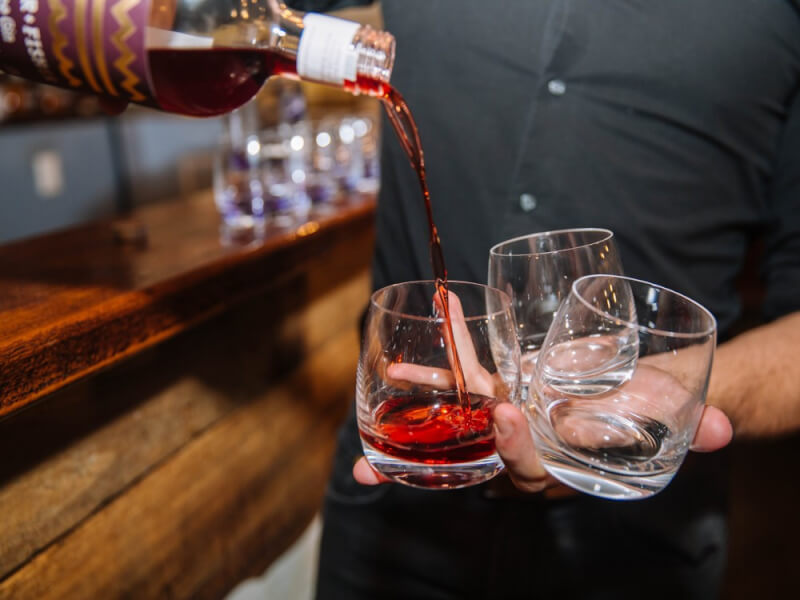 Hands pouring drink into glasses 