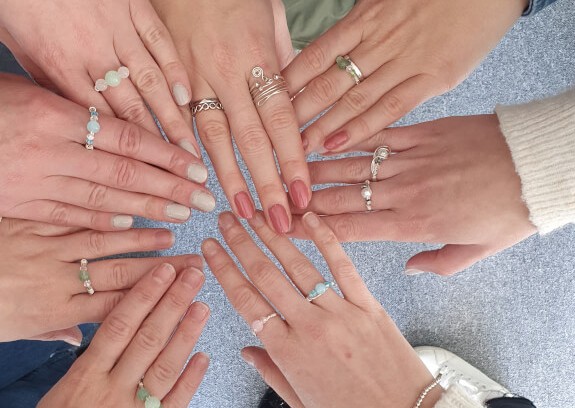 Hands wearing wire wrapped rings from a jewellery making class