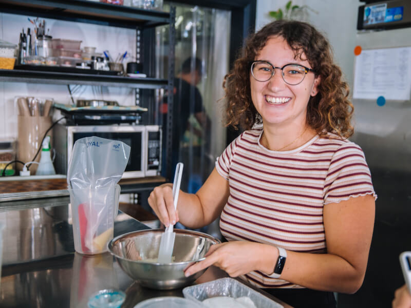 A woman is holding a mixing bowl at a baking class