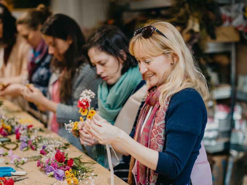 A group of women making flower crowns