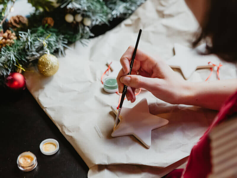 Someone painting a clay Christmas decoration